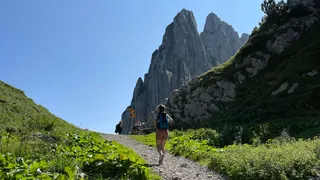 Young woman wanders to the rock massif at the campsite in Switzerland