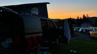 Black camper at sunset on campsite