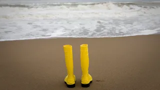 Yellow rubber boots on the beach